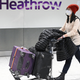 Passengers wear face masks as the push their luggage after arriving from a flight at Terminal 5 of London Heathrow Airport in west London on January 28, 2020.